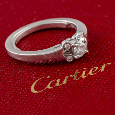 Cartier, Anillo en oro blanco de 18 kt con diamante central de 0,15qt y cuatro peque&ntilde;os brillantes a cada lado.
