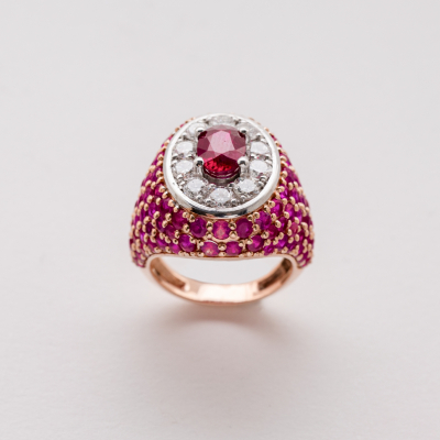 Sortija sello en oro rosa y blanco con cuerpo cuajado de rub&iacute;es talla redonda y roset&oacute;n central con rub&iacute; talla oval orlado por diamantes talla brillante.
