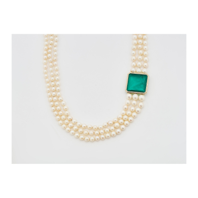 Collar de tres hilos de perlas japonesas cultivadas Mikimoto en degradé de 9 – 6 mm. con magnífica esmeralda colombiana talla octogonal de 63,37ct. enmarcada en oro y orlada por diamantes talla brillante.