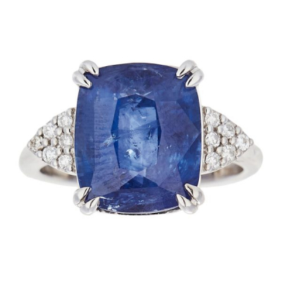 Sortija en oro blanco con zafiro azul talla cojín custodiado por triángulos de diamantes talla brillante.