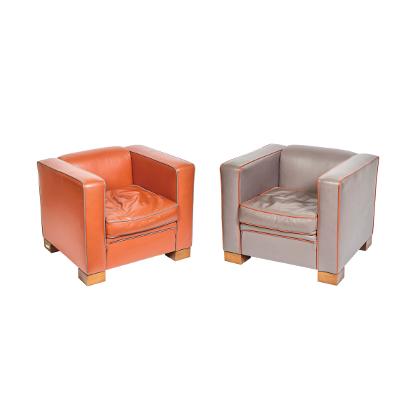 Manufactura David Linley (Londres, Inglaterra, 1985) Pareja de butacas modelo «Chase Chair» en cuero naranja y gris marengo bicolor con patas en madera de nogal con logotipo pirograbado.