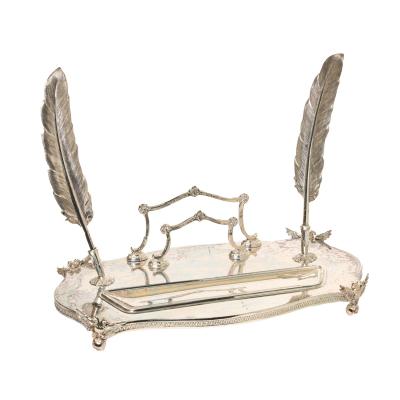 Escribanía en plata española punzonada con contrastes del orfebre Pedro Durán, s.XX. Decorada con motivos de gusto Imperio, con cenefa de palmetas y patas de bola bajo águila bicéfala. Adjunta dos plumas. 26 x 35 x 20 cm. Peso: 639 gr. Estimación:1100 – 1200€