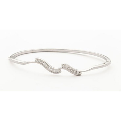 Pulsera rígida en oro blanco con diamantes talla brillante con un peso total de 0,40 cts. aprox.  representando olas.