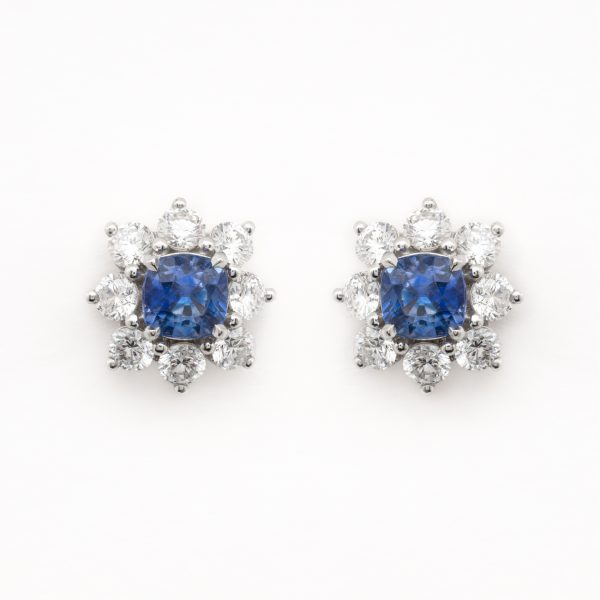Pendientes rosetón en oro blanco con zafiro azul talla cojín orlado por diamantes talla brillante.