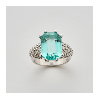 Sortija en oro blanco con esmeralda talla octogonal custodiada por diamantes talla brillante engastados en garras.