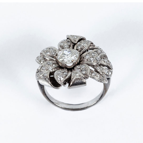 Sortija vintage, años 30, en oro blanco 18 K ó platino, diseño floral con un diamante central, talla cojín antigua de 0.90 ct aprox.