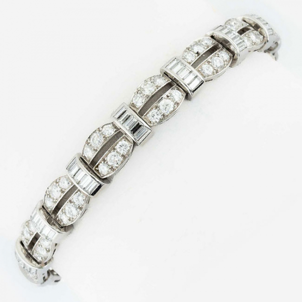 Elegante pulsera de alta joyerìa en sólida montura de oro blanco, cuajada de limpios y blancos diamantes, talla brillante y baguette, montados en eslabones articulados de doble banda curvada y banda transversal respect.