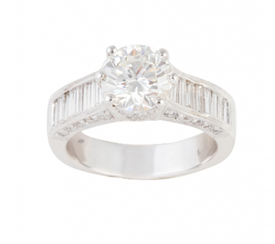 Sortija con brillante central de 2,01 ct con diamantes talla baguette en los brazos de la montura.   En oro blanco de 18 K.