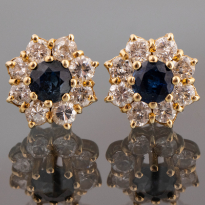 Pareja de pendientes en oro amarillo de 18kt con zafiro central orlado de brillantes.