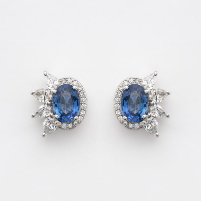 Pendientes en oro blanco con zafiro azul talla oval orlado por diamantes tallas brillante y perilla.