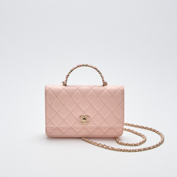 CHANEL. Bolso modelo «Top Handle» en piel de tonalidad rosa claro con cierre de pasador y cadena en metal dorado con asa rígida floral.