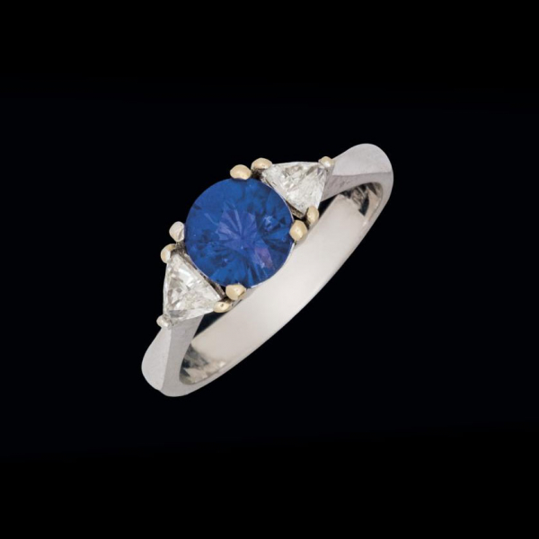 Anillo de oro blanco 18 K con zafiro azul y brillantes. 