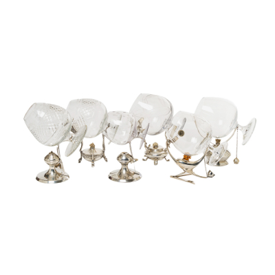 Lote formado por seis calentadores para copas de coñac en plata española punzonada en diferentes formas y tamaños, s.XX. Se acompañan de seis copas de coñac en cristal tallado.