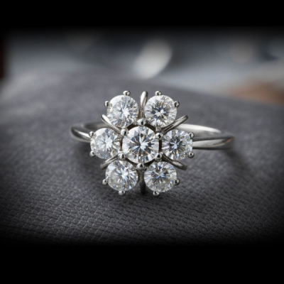 Exquisito anillo en forma de rosetón en oro blanco 18K con siete diamantes talla brillante.