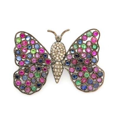 Broche en plata representando mariposa con cuajado de rubíes, zafiros, esmeraldas y diamantes.