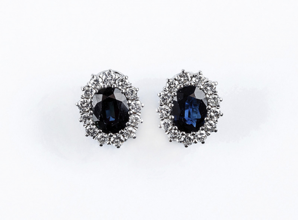 Bellos pendientes en oro blanco con zafiro azul y orla de limpios y blancos diamantes, talla brillante