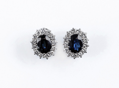 Bellos pendientes en oro blanco con zafiro azul y orla de limpios y blancos diamantes, talla brillante