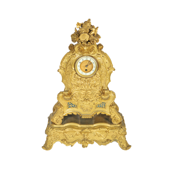 Reloj de sobremesa estilo transición Luis XV-Luis XVI en bronce dorado con decoración de roleos, acantos, rocallas, veneras y motivos florales, s.XIX.
