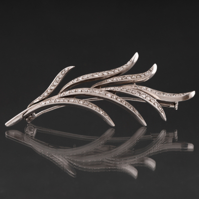 Bonito broche en forma de hoja en oro blanco de 18kt orlado de brillantes.