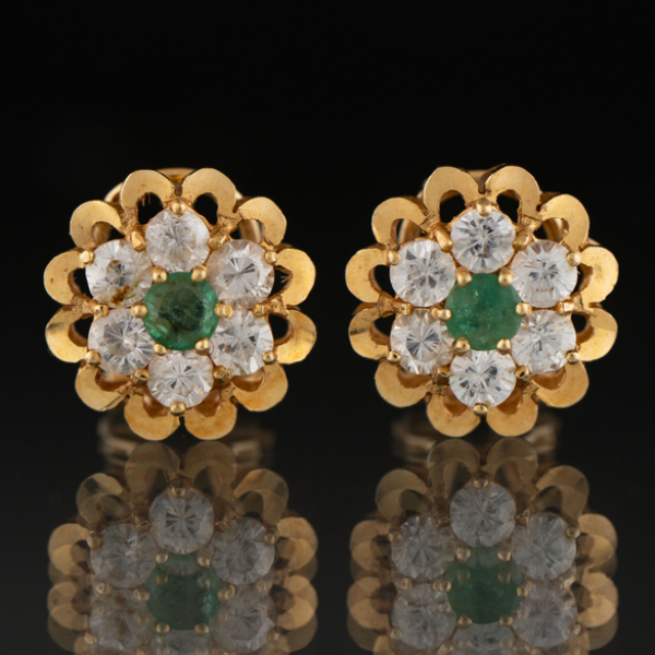 Pareja de pendientes en forma de flor oro amarillo de 18 kt con esmeralda central.