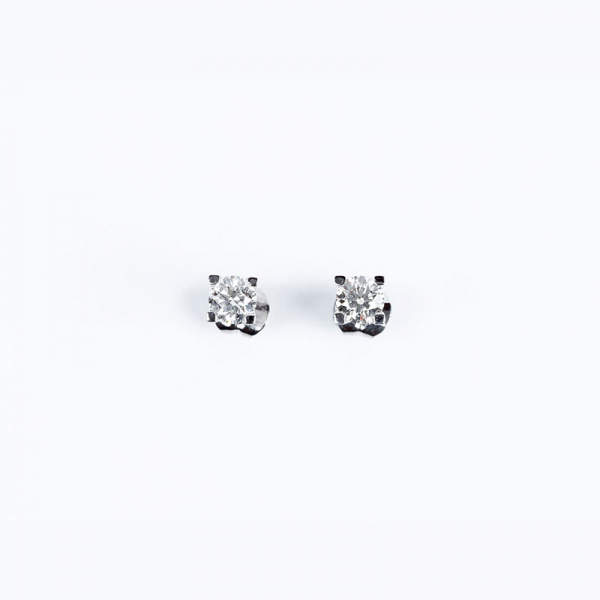 Pendientes solitario en oro blanco con un limpio y blanco diamante, talla brillante, en cuatro fuertes garras