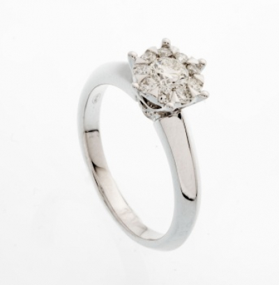 Sortija en oro blanco con diamante talla brillante central y orla de diamantes talla brillante a los lados