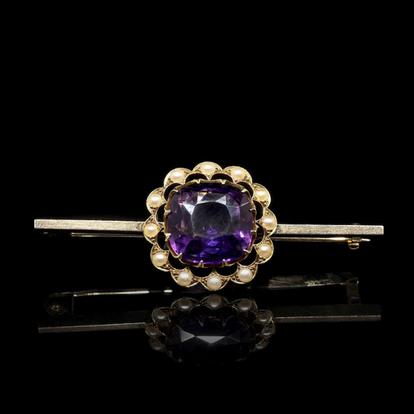 Broche de oro amarillo de 15 kt con amatista violeta talla cojín y orla de perlas. 