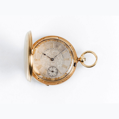 Excelente reloj saboneta de los relojeros de Madrid G.RIESTERER y M. ARREGUI (Relojeros de Cámara de los Reyes de España), en sólida caja de oro amarillo, 52 mm., de tres tapas, las exteriores con decoración en guilloché y la guardapolvos lisa.
