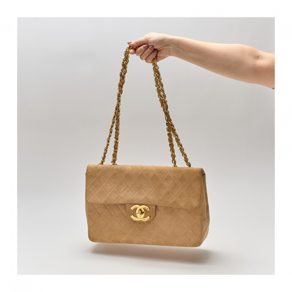 CHANEL. Bolso modelo «Timeless Classic» en ante de tonalidad marrón camel con cierre de una solapa y pasador en el logotipo.