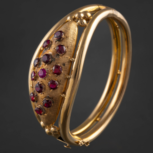 Pulsera rígida en oro amarillo de 18kt con rubíes sintéticos y granates.