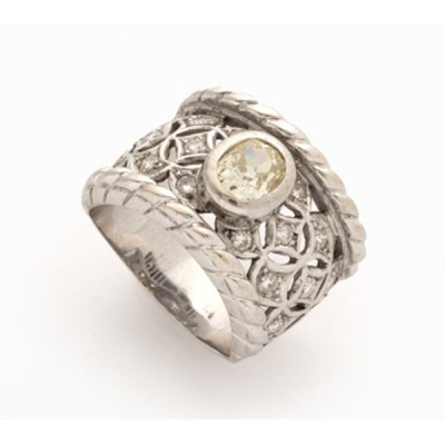 Sortija en oro blanco con diamante talla oval central, cuajados de diamantes talla brillante a los lados con decoración vegetal y cordón