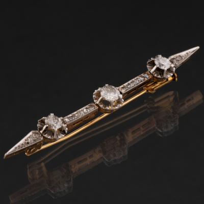 Alfiler en oro amarillo y oro blanco de 18kt con tres diamantes talla brillante.