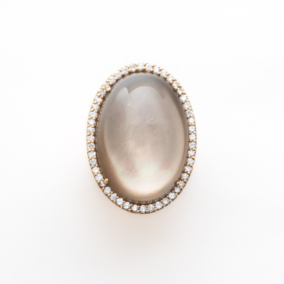 Sortija en oro satinado con cabuj&oacute;n oval de piedra luna orlado por diamantes talla brillante 