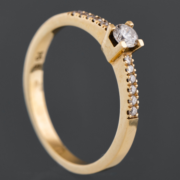 Anillo montado en oro amarillo de 18kt con diamantes talla brillante y orlado de brillantería 0,25 Qt.