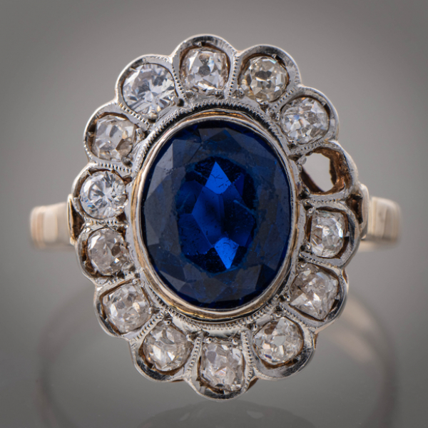 Anillo en oro amarillo de 18kt con brillantes talla antigua y zafiro central