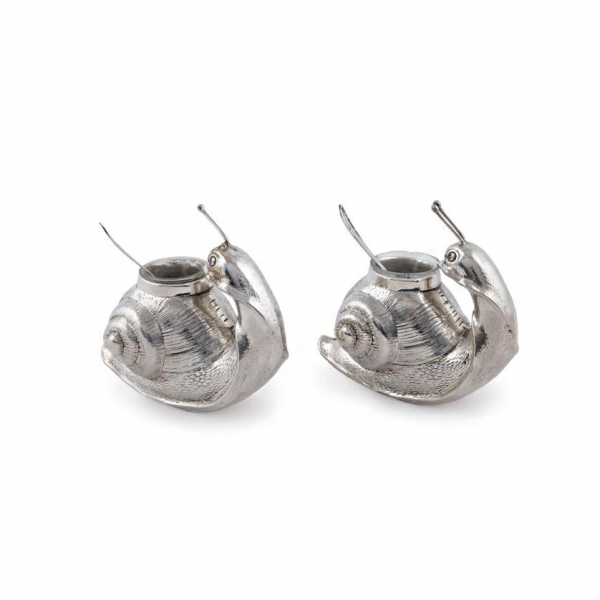 Pareja de delicados saleros en plata punzonada, ley 925, posiblemente mejicana o peruana. A modo de caracoles. Con depósito en cristal y cucharita de plata. S. XX.