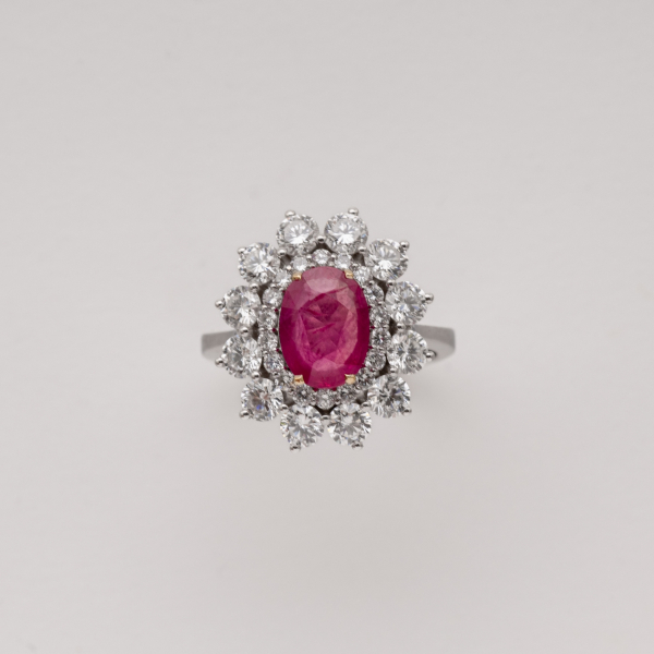 Sortija rosetón en oro blanco con rubí de Myanmar ( Burma ) talla oval orlado por diamantes talla brillante.
