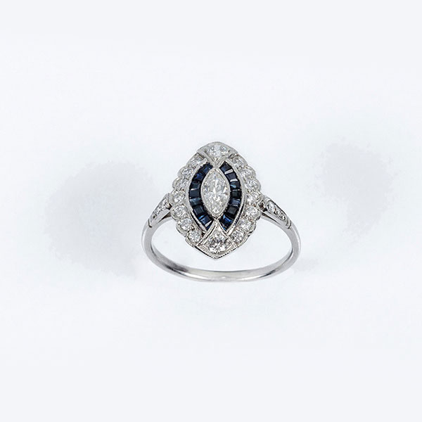 Delicada sortija estilo art-decó en platino, con un limpio y blanco diamante talla marquisse, zafiritos azules y limpios y blancos diamantes talla brillante 