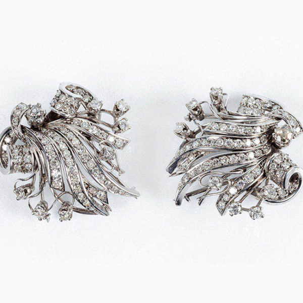 Conjunto vintage de dos clips de solapa en platino, con motivo vegetal y lazada, cuajados de limpios y blancos diamantes 