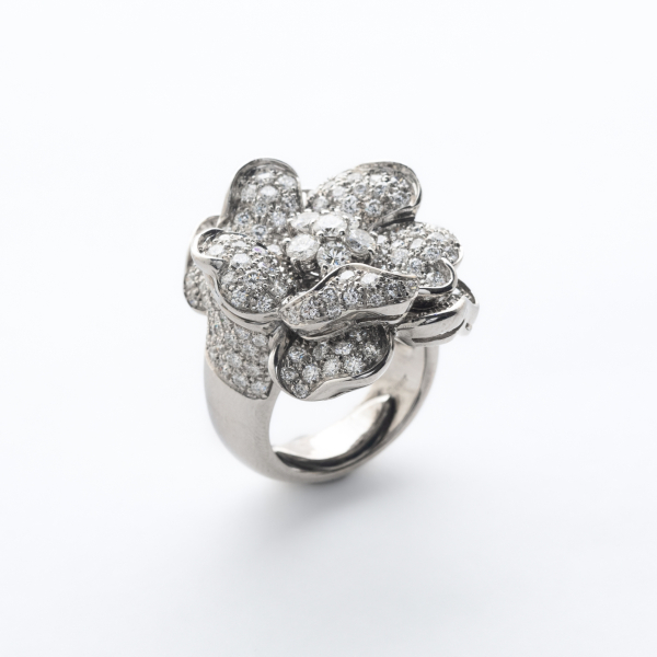 Sortija dise&ntilde;o flor en oro blanco con diamantes talla brillante engastados en garras y gran&eacute;. 