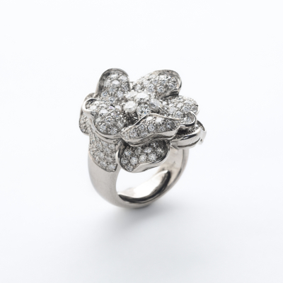 Sortija dise&ntilde;o flor en oro blanco con diamantes talla brillante engastados en garras y gran&eacute;. 