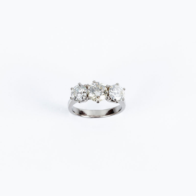 Anillo tresillo en montura de oro blanco con diamantes en garras, el central talla brillante moderna 