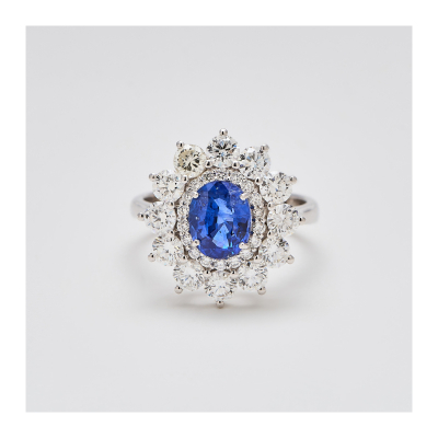 Sortija rosetón en oro blanco y zafiro azul de Sri Lanka talla oval con doble orla de diamantes talla brillante engastados en garras.