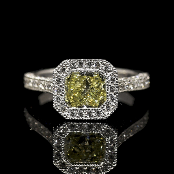 Sortija realizada en oro blanco de 18 k con orla de diamantes y diamante natural talla radiant de 1,53 ct, color Fancy Yellow natural  