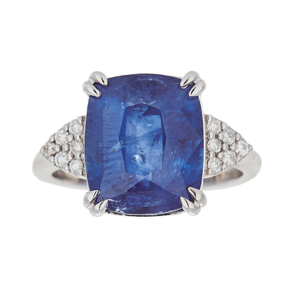 Sortija en oro blanco con zafiro azul talla cojín custodiado por triángulos de diamantes talla brillante.