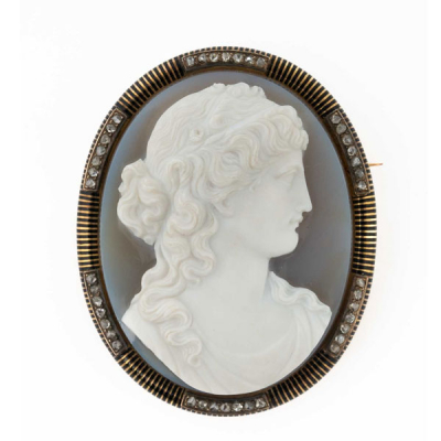 Espléndido alfiler antiguo, en oro rosa 18 K, con gran camafeo sardónico de busto neoclásico con orla de media caña decorada con franjas negras esmaltadas y tramos en bandas de blancos diamantitos talla simple