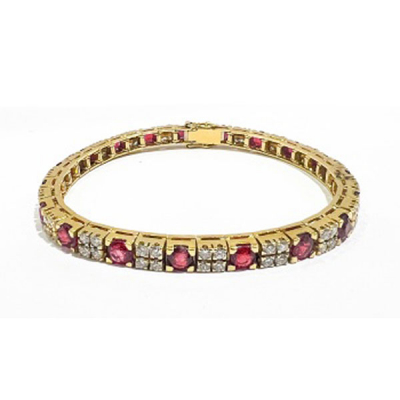 Pulsera en oro amarillo formando lazos con 9 rubíes cuajados de diamantes talla brillante.
