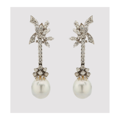 Pendientes largos en oro blanco con hojas, lazada y barrita de diamantes talla brillante rematadas por perla cultivada barroca de 13 x 11 mm.