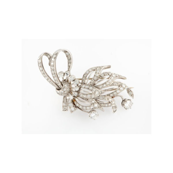 Broche en platino formando lazo con 9 diamantes talla brillante y con cuajado de diamantes talla brillante con un peso total de 2 cts. aprox.