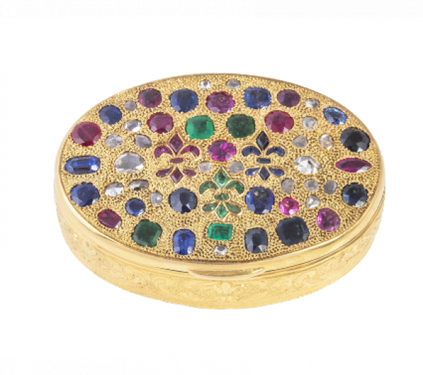 Caja oval S. XIX de oro, con tapa cuajada de zafiros, esmeraldas, rubíes y diamantes de talla rosa rodeando dos flores de lys.  